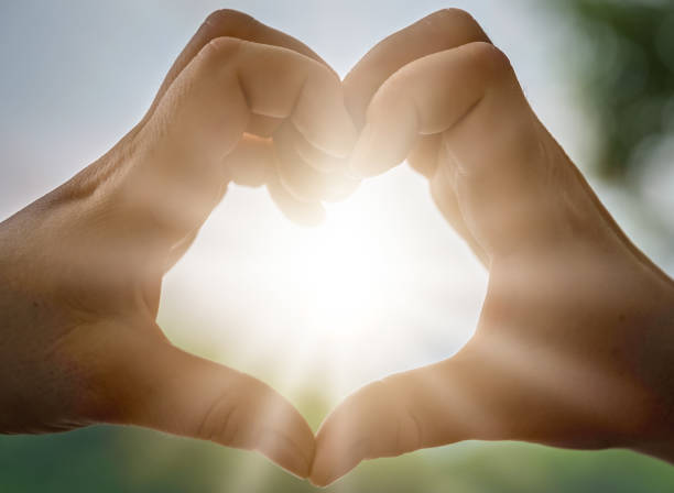 istock Womans hands catching sunlight at dusk 1194950569