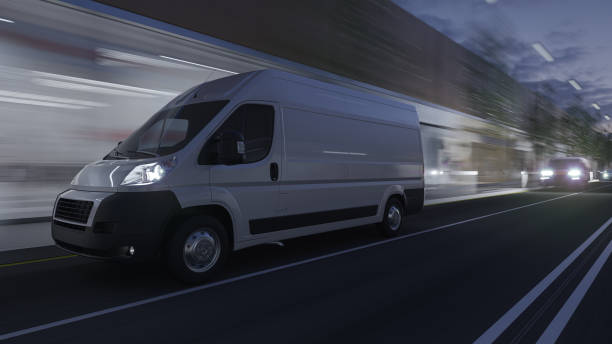 White Delivery Van Moving on the Road in Dim Evening Light stock photo