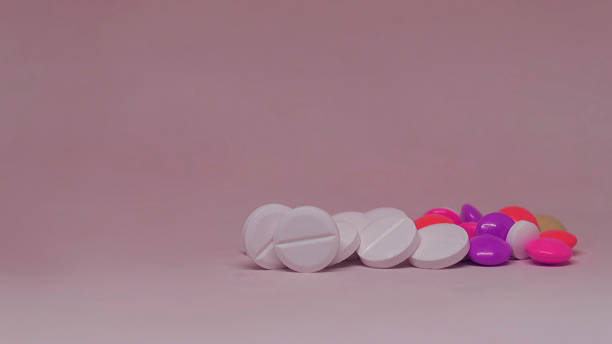 istock Various multicolor pills lying on dark purple background 1194951510