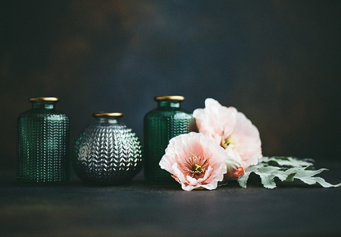 Still life background with small glass jars and pink poppies