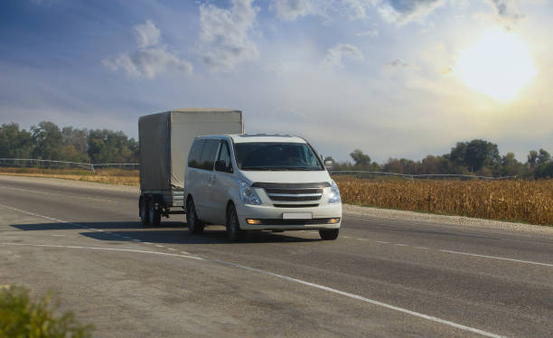istock Minivan with trailer. Moving along a suburban highway 1194954404