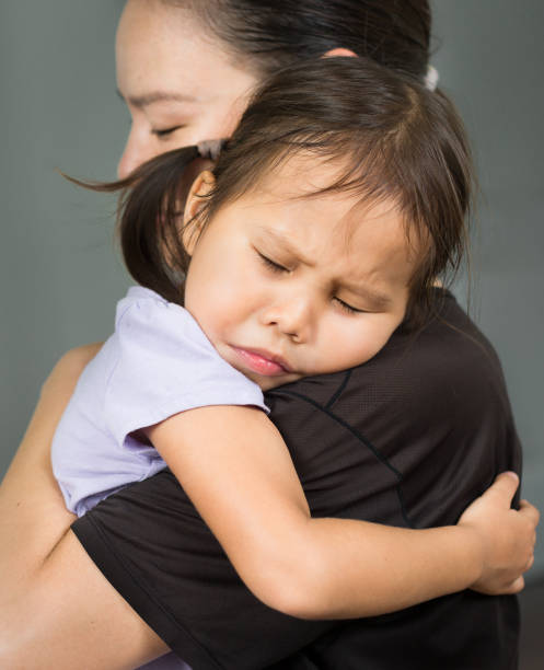 Mother hugging and comforting her child in her arms. Parent love and comfort. Young toddler holding her mother to feel safe and secure. Family love and support. separation anxiety in babies stock pictures, royalty-free photos & images