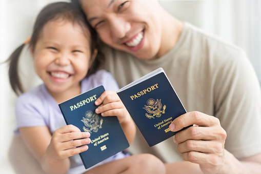 Familia inmigrante feliz convirtiéndose en nuevos ciudadanos estadounidenses, con pasaportes estadounidenses. photo