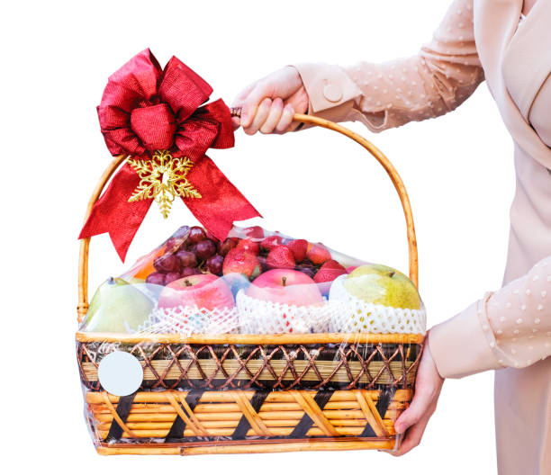 giovane donna che tiene un cesto regalo di frutta di capodanno isolato su sfondo bianco - gift apple ribbon fruit foto e immagini stock