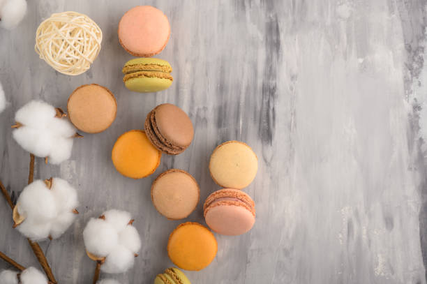 istock Colored french macaroons, sweets with cotton branches. On a marble background with space 1194964412