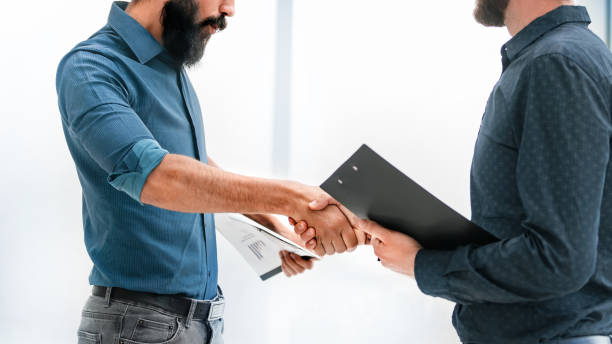 istock successful businessman shaking hands with uncertain customer 1194968032