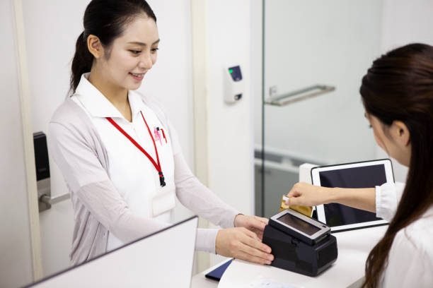 pago de pacientes en la clínica - healthcare and medicine receptionist paying credit card fotografías e imágenes de stock