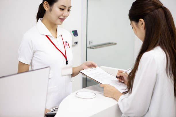 patient zahlt in klinik - healthcare and medicine receptionist paying credit card stock-fotos und bilder