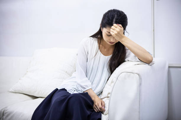 病室で頭を抱えている女性患者 - うつ病 末期症状 ストックフォトと画像