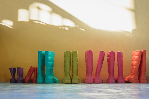 Many pairs of children's boots are placed in the room at home or kindergarten