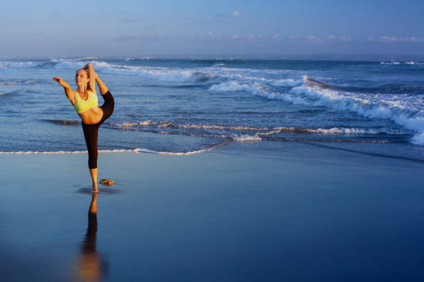 istock Woman stretching at yoga pose on sunset beach 1194977032