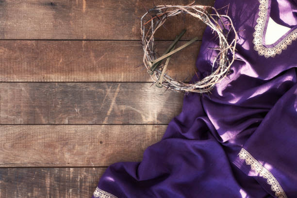 Easter Jesus Crown of Thorns and Nails Lying on a Royal Purple Robe against a Rustic Wood Background Easter Jesus Crown of Thorns and Nails Lying on a Royal Purple Robe against a Rustic Wood Background ceremonial robe stock pictures, royalty-free photos & images