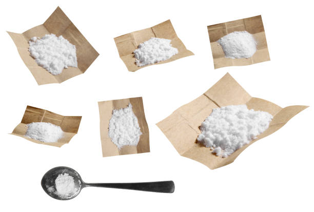 gruppo di cocaina in carta e cucchiaio isolato su sfondo bianco - anfetamine foto e immagini stock