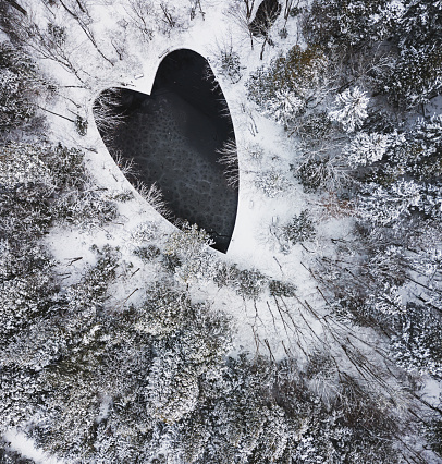 Aerial drone view of a heart shaped pond in Winter.