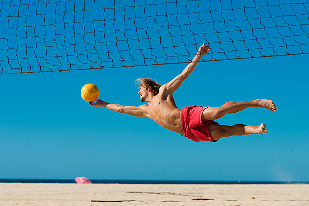 beach-volleyball-mann springt - strand volleyball stock-fotos und bilder