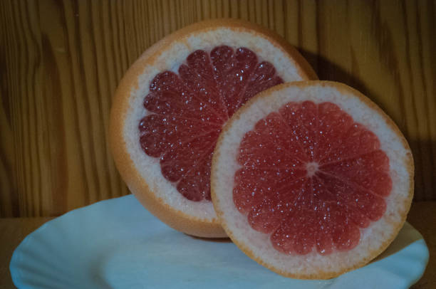 istock pink grapefruit in a cut on a white plate 1194989791