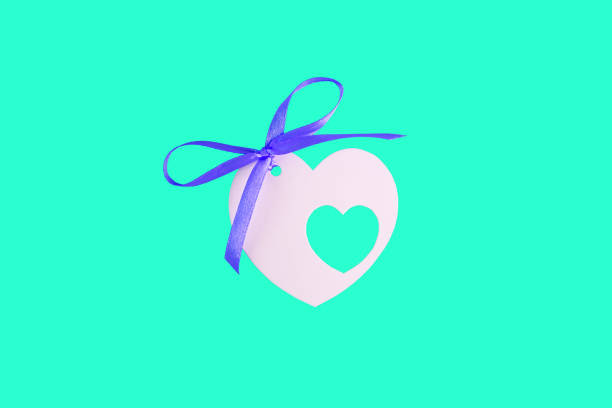 étiquette blanche de carte en forme de coeur sur un flatlay aqua turquoise à la mode, concept minimal créatif. carte de jour de valentines, espace de copie - gift purple turquoise box photos et images de collection