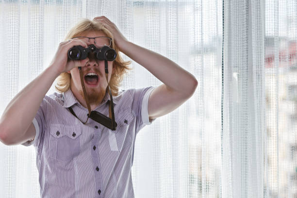 istock Man with binoculars spying on neighbors 1195002891
