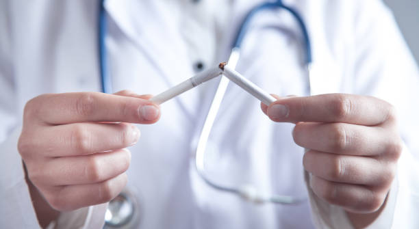 istock Doctor holding broken cigarette. Stop smoking 1195003669