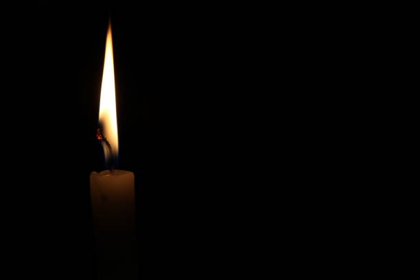 istock One light candle burning brightly in the black background 1195006634