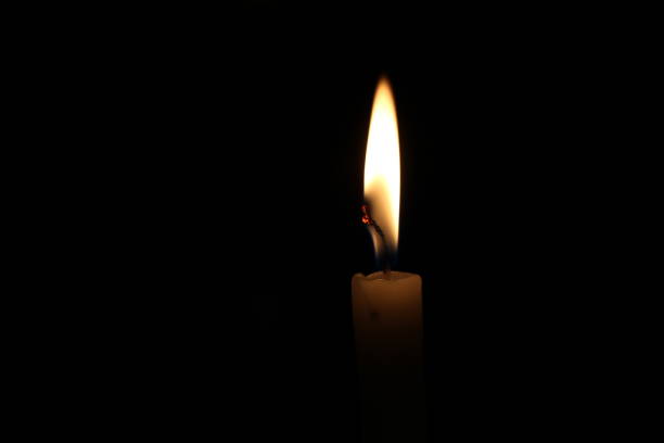 istock One light candle burning brightly in the black background 1195007167