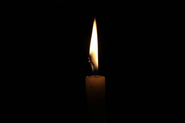 istock One light candle burning brightly in the black background 1195007176