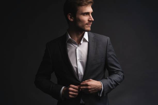 istock Portrait of serious handsome man in gray suit buttoning jacket 1195007242