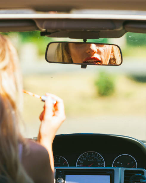 istock Girl apply make up while driving car. 1195007245