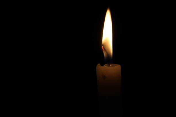 istock One light candle burning brightly in the black background 1195007256
