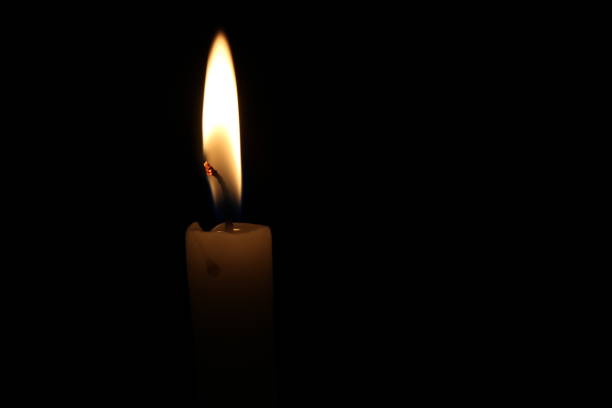 istock One light candle burning brightly in the black background 1195007353