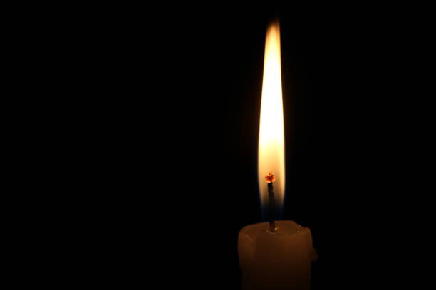 istock One light candle burning brightly in the black background 1195007549