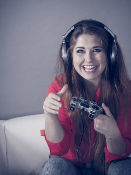 istock Young woman playing video games 1195007562