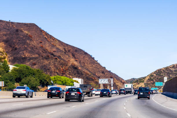 Cars driving on Highway 405, Los Angeles Dec 9, 2019 Los Angeles / CA / USA - Cars driving on Highway 405; Burned hills visible on the left side as result of Getty Fire; highway 405 photos stock pictures, royalty-free photos & images