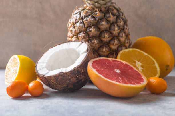 istock Fresh exotic fruits a on pastel grey  background - pineapple, grapefruit, coconut, orange. 1195007636