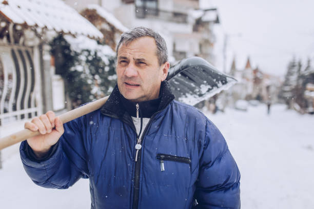 istock Senior man cleans snow 1195013698