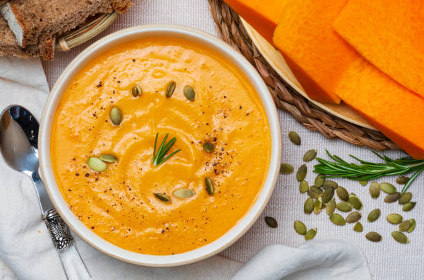 istock Delicious pumpkin cream. Home and rustic appearance. Includes fresh pumpkin, seeds and rye bread. Aerial view. 1195013752