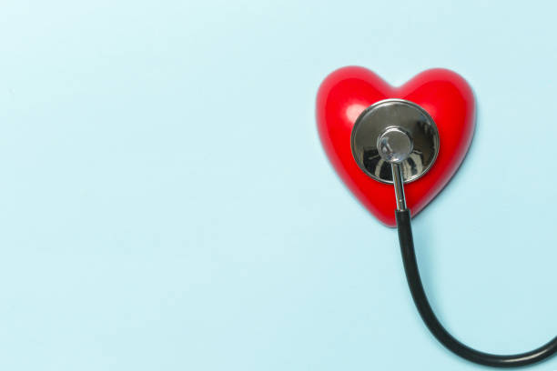 istock Red heart and a stethoscope isolated on blue background 1195014433