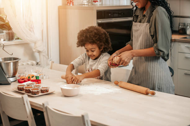 istock Girl Making Gingerbread Cookies With Mom 1195016301