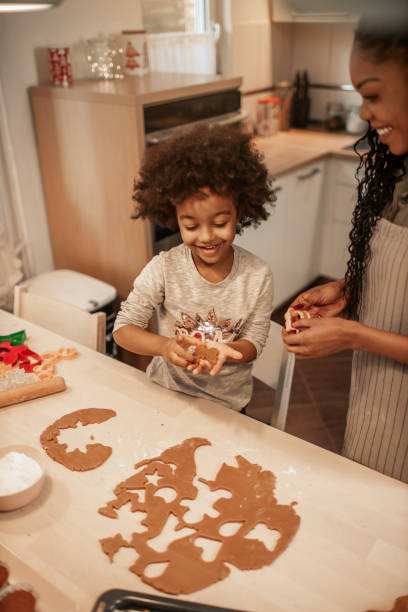 istock Girl Making Gingerbread Cookies With Mom 1195016350