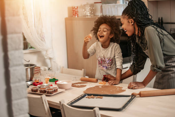 istock Girl Making Gingerbread Cookies With Mom 1195016351