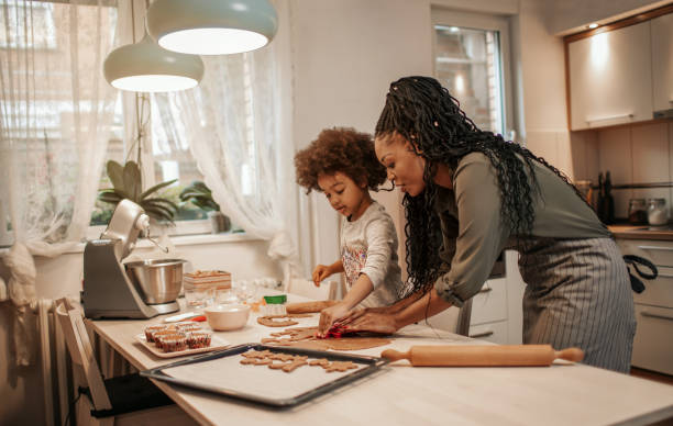 istock Girl Making Gingerbread Cookies With Mom 1195016437
