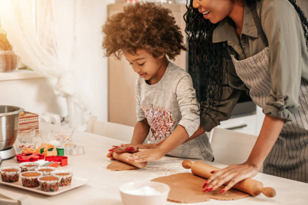 istock Girl Making Gingerbread Cookies With Mom 1195016477