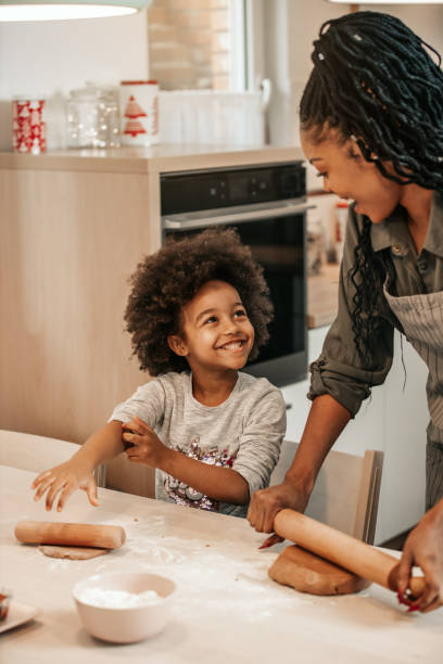 istock Girl Making Gingerbread Cookies With Mom 1195016560