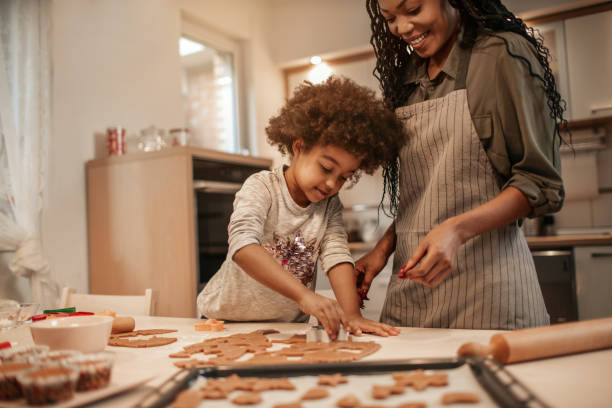 istock Girl Making Gingerbread Cookies With Mom 1195016670