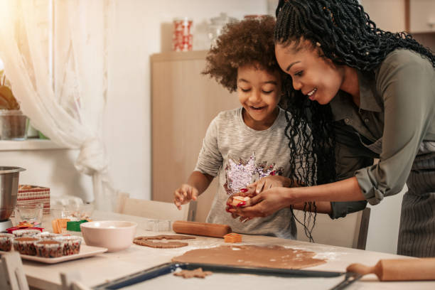 istock Girl Making Gingerbread Cookies With Mom 1195016673