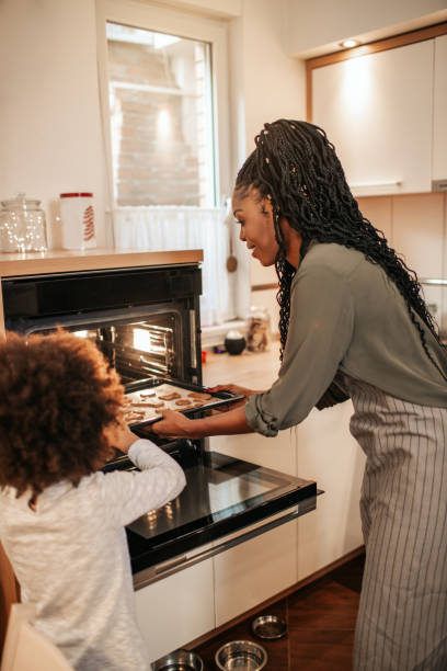 istock Girl Making Gingerbread Cookies With Mom 1195016706