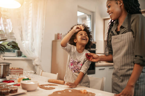 istock Girl Making Gingerbread Cookies With Mom 1195016709