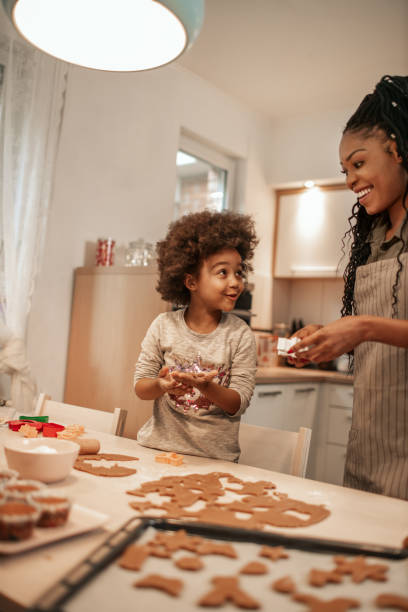 istock Girl Making Gingerbread Cookies With Mom 1195016761