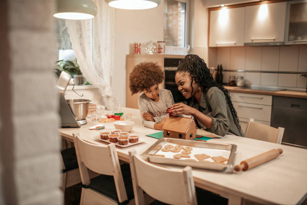 istock Mother And Her Daughter Assemble Gingerbread House 1195016816