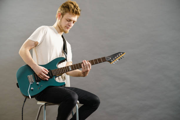 istock Young man playing electric guitar 1195018124